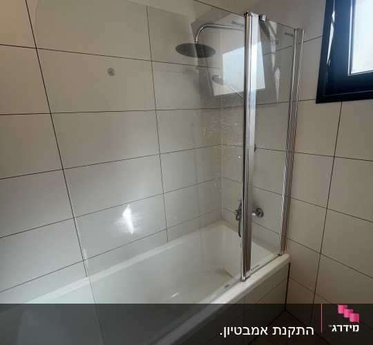 מקלחת עם דלת זכוכית ואמבטיה לבנה